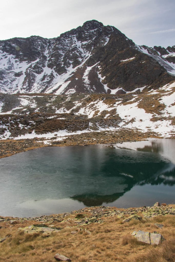 Un lac d'altitude à moitié gelé dans les Pyrénées à l'automne