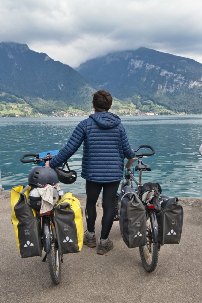 Voyageur à vélo face à un lac en Suisse